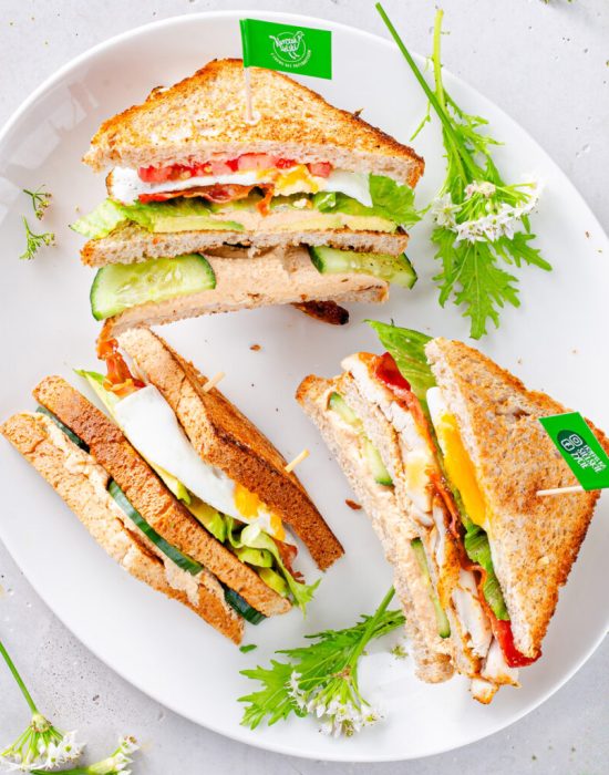 Sandwich z pastą z kurczaka, chrupiącą piersią, sadzonym jajkiem i boczkiem